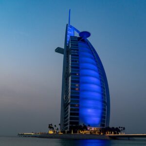 Stunning view of Burj Al Arab lit up in blue at twilight in Dubai, UAE.